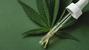 cannabis leaf and a dropper bottle filled with a liquid, likely representing medical cannabis or CBD oil